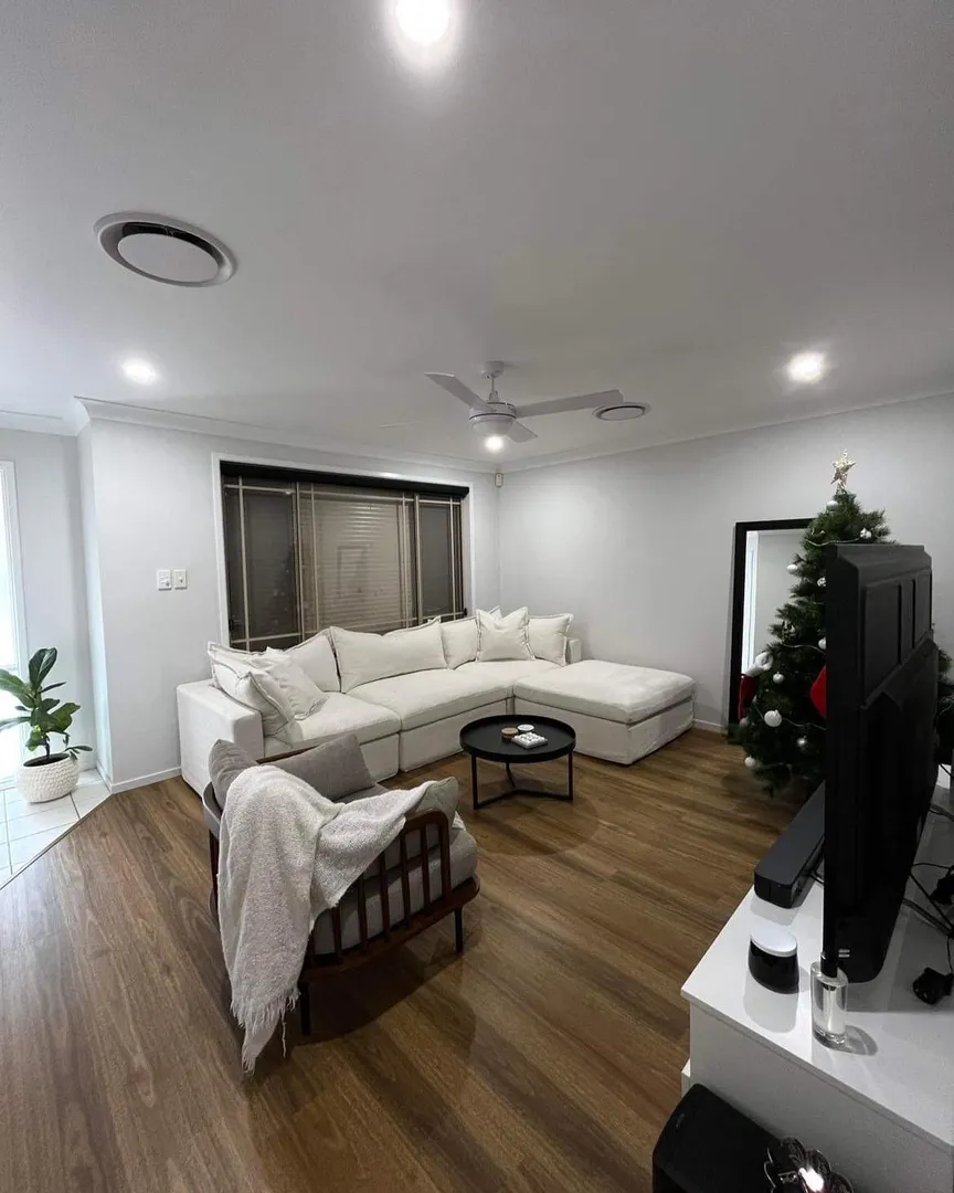 Modern living room with Christmas tree and sectional sofa.